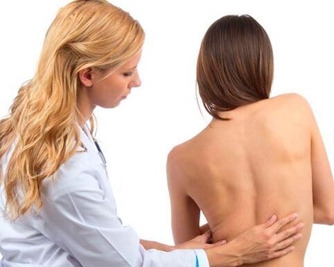 The doctor examines the lower back for lower back pain